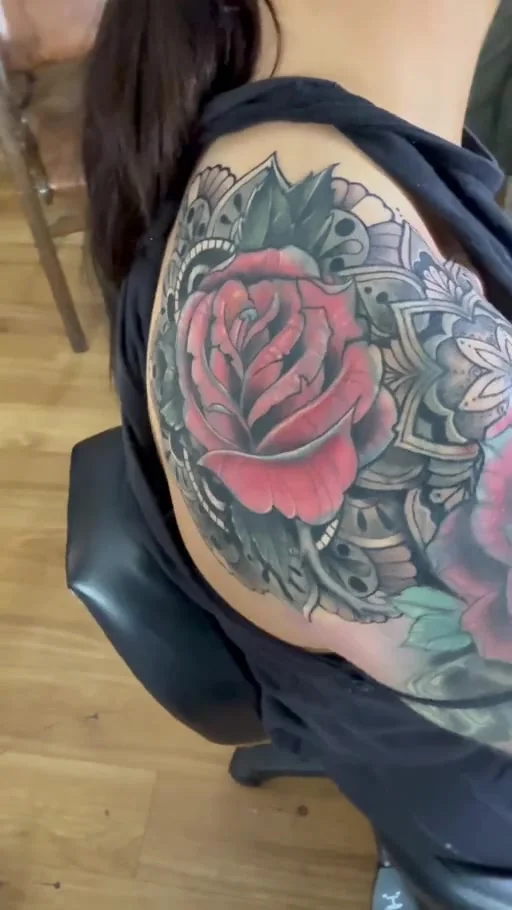 Red roses with shaded ornamental details on a shoulder