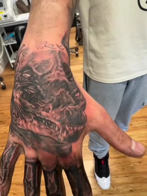 Detailed macabre skull tattoo across the back of a hand